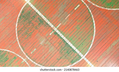 Top View Of The Golden Gun. School Gym With Old Wooden Covering And Multi Colored Paints Of The World, Background Image, Empty Space For Your Slogan, Tinting, Vignetting, Selective Focusing