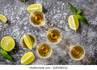 Top view of Golden Tequila shots served with lime and sea salt on table