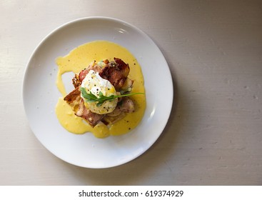 Top View Of Gourmet Eggs Benedict With Bacon