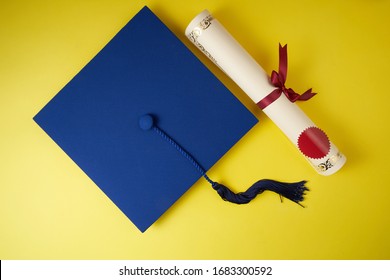 Top view of graduation mortarboard and diploma on yellow background, education concept