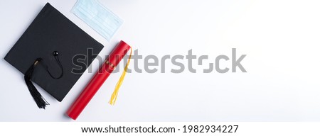 Top view of graduation square academic cap with degree diploma and mask isolated on white table background.