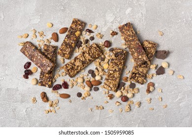 Top view of granola energy bar with mix of nuts for healthy nutrition on gray concrete background with copy space - Powered by Shutterstock