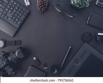 top view of graphic design and photographer concept with digital camera, memory card, smartphone, graphic tablet, and keyboard on black background with copy space