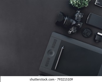 Top View Of Graphic Design Work Station, Work Space Concept With Digital Camera, Memory Card, Graphic Tablet On Black Background With Copy Space