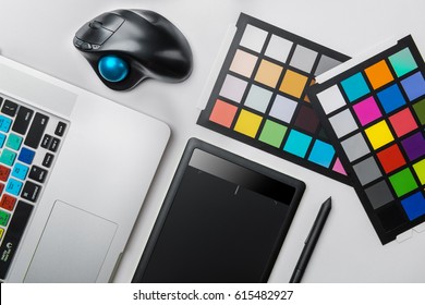 Top view of graphic designer desk. Laptop, trackball mouse, digital graphic tablet
