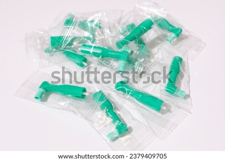 Top View Green Disposable Prophy Angles with Brush, Ergonomic Shape on White Background. Dentistry, Orthodontic Product. Oral Hygiene. Horizontal Plane . High quality photo