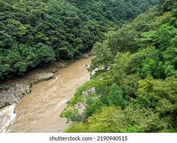 Top View Of Green Forest And Muddy Water Brook With Small Rafting Boat.enjoy Outdoor Life Concept.