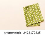 top view with green kitchen napkin isolated on table background. Folded cloth for mockup with copy space, Flat lay. Minimal style.