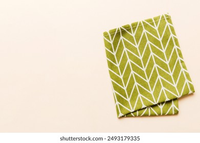 top view with green kitchen napkin isolated on table background. Folded cloth for mockup with copy space, Flat lay. Minimal style.