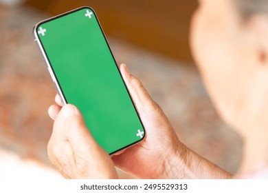 Top view green screen phone mockup with space for design hands of elderly woman. no face. Concept: use of modern smartphone technologies at retirement age. Template. apps or video call  - Powered by Shutterstock