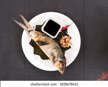 Top view of Grilled Boneless Bangus stuffed with vegetables and served with soysauce and Atchara. Bangus is also known as Milkfish.