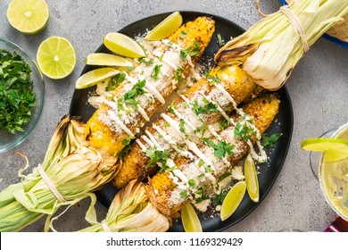 Top view. Grilling mexican street corn elote garnished with spices on a serving plate.