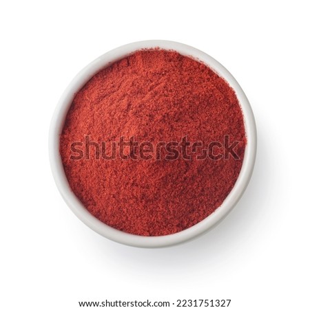 Top view of ground paprika powder in ceramic bowl isolated on white