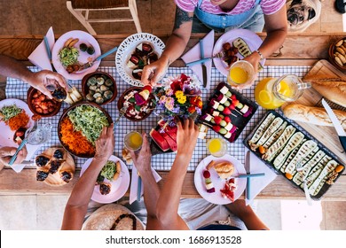 Top View Of Group Of Friends Having Fun Together In A Healthy Vegetarian Fresh Seasonal Brunch Together - Coloured And Energetic Food To Eat With Friends Or Family - People Sta At Home Or Restaurant