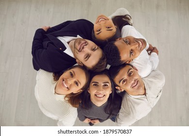 Top View Of Group Of Happy Smiling Young Diverse People Standing In Circle And Looking Up At Camera All Together. Concept Of Business Team, Teamwork, Collaboration, Support, Unity And Common Goal