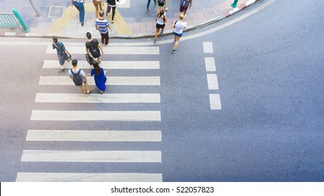 Top View Of Group Men And Women And People Walk On The Crosswalk With White Sign Pedestrian On The City Street (aerial City Street View) 