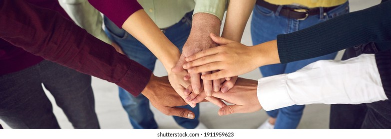 Top view of a group of people of different ages and nationalities fold their arms as a symbol of cooperation. Concept of teamwork, cooperation, unity, trust and support. Close up.