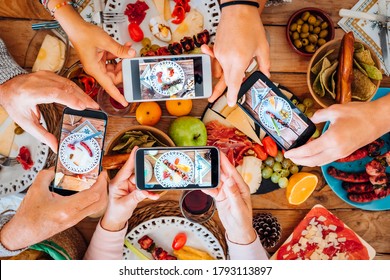 Top View Of Group Of People During Christmas Night Taking Food And Dishes Picture With Smartphone All Together - Concept Of Party Celebration Tradition With Family And Friends And Technology