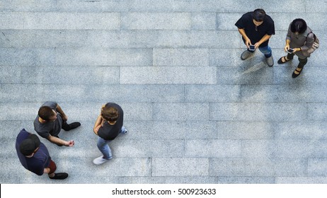 Top View Group Of People Are Playing And Talking With The Smart Phone On The Concrete Pedestrian (Aerial Top View)