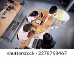 Top view of a Group of students from the technical college using a laptop in technology class. Classmates collaborating on a project in high school - programming at classroom. High quality photo