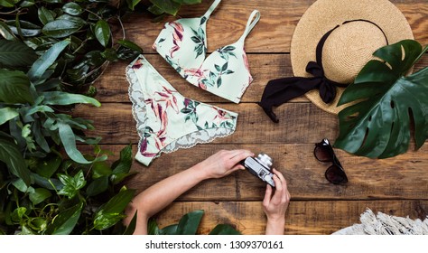 Top view of group of summer objects on wooden background. Swimwear, sunglasses and exotic levies.