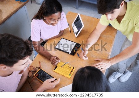 Top view of a group of technical college students doing a team technology project. . High quality photo