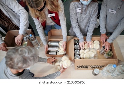 Top view of group of volunteers collect donations for Ukrainian refugees, humanitarian aid concept. - Shutterstock ID 2130605960