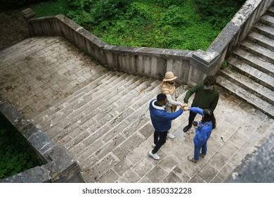 Top View Of Group Of Young People Greeting Outdoors In Town. Coronavirus Concept.