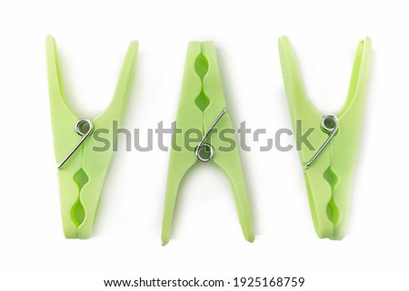 top view of grreen clothespins on white background