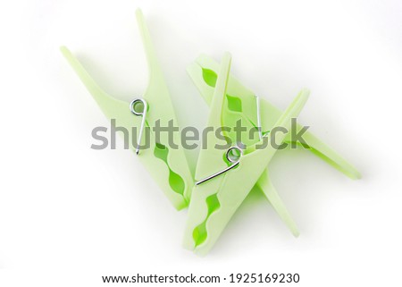 top view of grreen clothespins on white background