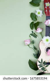 Top View Of A Guitar And Flowers On Green Background. Beautiful Postcard , Cover For Musical Album, Wallpaper Close Up Copy Space