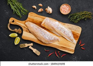 Top View Of Haddock Fillet With Seasoning On Wooden Cutting Board