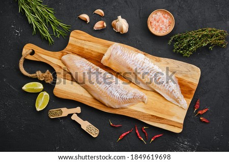 Top view of haddock fillet with seasoning on wooden cutting board Foto stock © 