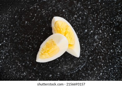 Top View Of Half Of Boiled Egg Cut On Two Pieces On A Plate