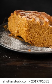 Top View Of Half Yogurt Sponge Cake On Dark Plate, On Wooden Table And Black Background, In Vertical, With Copy Space