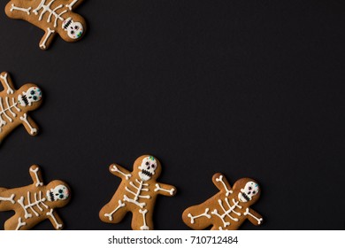 top view of halloween cookies in shape of skeletons isolated on black