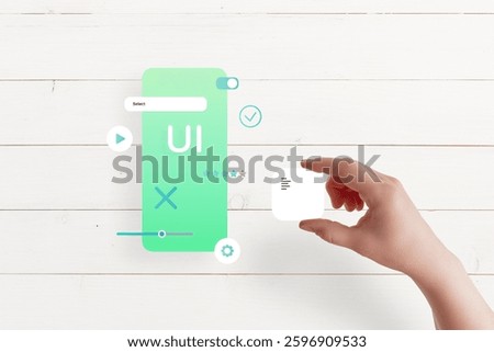 Top view of hand assembling app interface on table, placing text box, concept of UI UX design and mobile app development