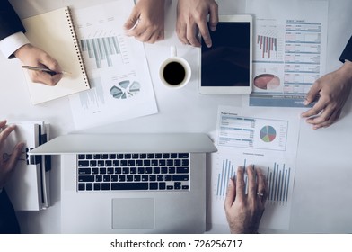 Top view hand of business team during meeting conference are working documents about the marketing plan and sales profit finance of the company with laptop computer and smartphone tablet on work table - Shutterstock ID 726256717
