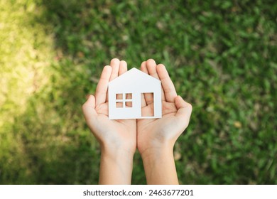 Top view hand hold house icon, presenting house loan opportunity as part of real estate sales. Promoting eco-smart homes, embodying vision for sustainable bright future nurturing with nature. Gyre - Powered by Shutterstock