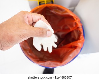 Top View Hand Holding Medical Gloves Dispose And Infectious Waste In Red Plastic Bag Infection Bin.Infectious Waste Control Concept.
