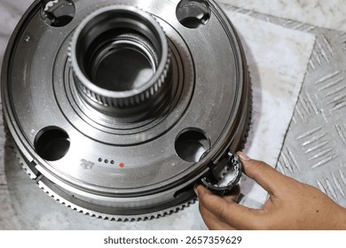 Top view hand installing driven gear on planetary gear of automatic transmission.