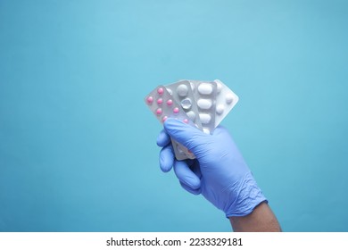 top view of hand in latex gloves holding blister pack  - Shutterstock ID 2233329181