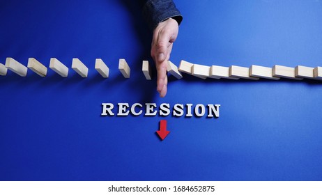 Top view: Hand of a man stopping falling blocks on blue background. Recession word with red down arrow on a table. - Shutterstock ID 1684652875