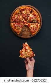 Top View Of Hand Take Homemade Pizza On Black Background