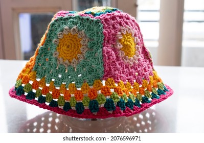 Top View Handmade Product To Make Spring Present, Colorful Bucket Hat With Many Piece Link Together, Cute Crochet Hat From Yarn On White Background