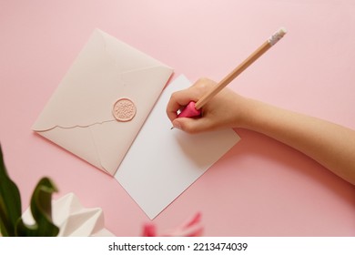 Top View Of Hands Of Anonymous Child Holding Pink Envelope With Gift Certificate.Good For Mother Day.