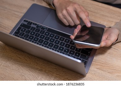 top view of hands with computer and mobile phone on desk