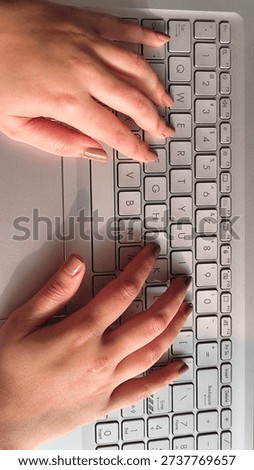 Top view of hands positioned on a laptop keyboard, symbolizing digital work, online tasks, and modern technology usage.