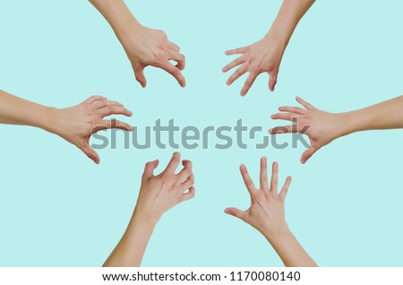 Top view of hands reaching for something isolated on a green, pastel background. The concept of wanting to grab something, gain.