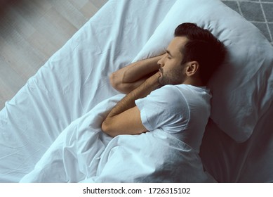 Top view of handsome calm male lying on pillow and sleeping in morning stock photo
